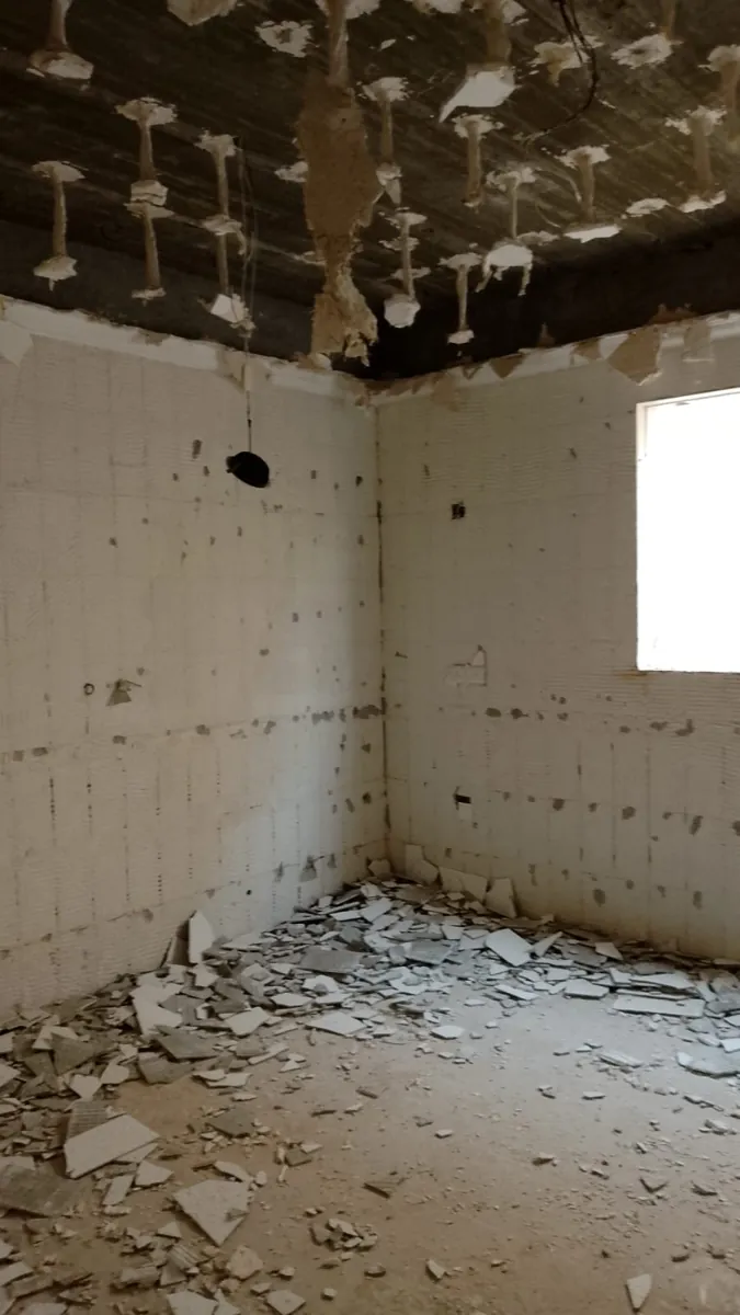 غرفة بعد إزالة السقف الجبسي وبلاط الجدران في مرحلة التكسير